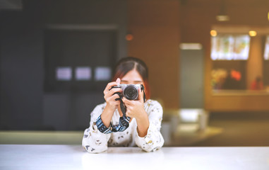 Asian girl student learns photography with small pocket camera outdoor at day in the park or university campus