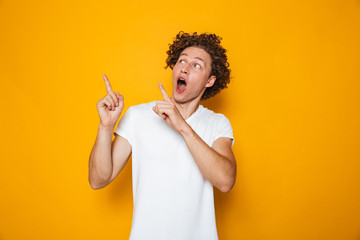 Portrait of a cheerful curly haired man pointing