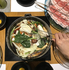 Japanese nabemono hotpot dish of thinly sliced meat and vegetable boiled in water served with...