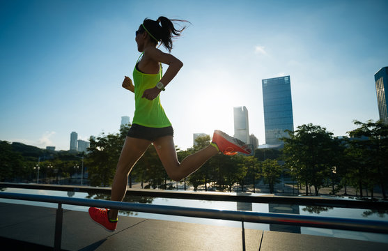 Healthy lifestyle fitness woman runner running on sunrise city