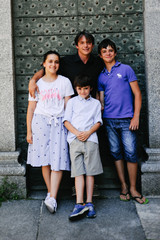 Father with his three sons poses in front of an old ancient monument door