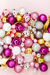 Holiday  arrangement with Stylish Christmas shiny baubles and gold crystals on pastel pink background. Flat lay, top view