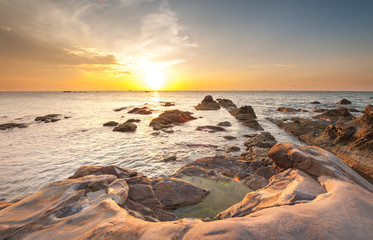 beautiful sunset at the beach. bright sun and beautiful cloud formation. slow shutter effect.