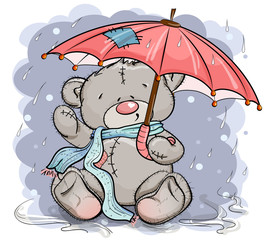 Teddy bear in a scarf sitting under an umbrella