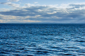 Obraz premium Waves on surface of water with cloudy sky