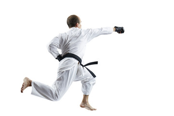 In white karategi and black gloves, the athlete beats with a hand in the jump isolated