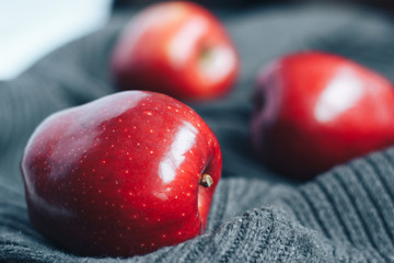 Red apples on gray woolen background