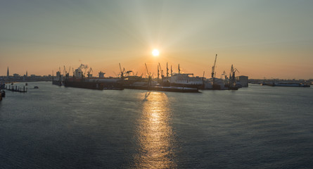 Der Hamburger Hafen bei Sonnenaufgang mit Elbphilharmonie im Hintergrund
