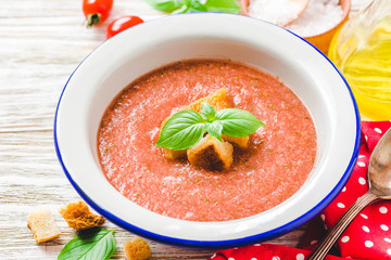 Healthy summer cold tomato soup, gazpacho with basil and garlic bread. Selective focus, space for...