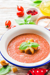 Healthy summer cold tomato soup, gazpacho with basil and garlic bread. Selective focus, space for text.