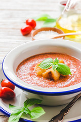 Healthy summer cold tomato soup, gazpacho with basil and garlic bread. Selective focus, space for text.