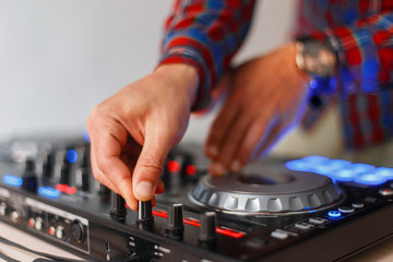 Close-up of the male DJ hands are played on the audio mixing console