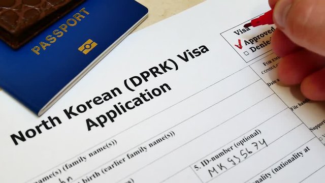 Decision to grant North Korean DPRK Visa. Approved in application form with passport and pen
