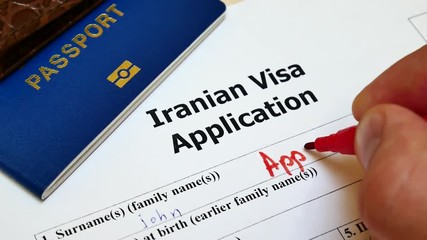 Decision to grant a Iranian Visa. Approved in Application form with passport and pen. Document with passport, apply and permission for foreigner country