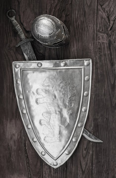 Medieval Shield And Sword On A Wooden Background