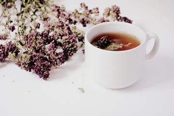 Obraz na płótnie Canvas Cup of herbal tea and herbs on a light background. Copy space