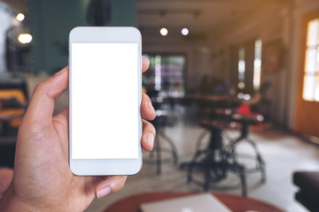 Mockup image of a hand holding white mobile phone with blank desktop screen in cafe