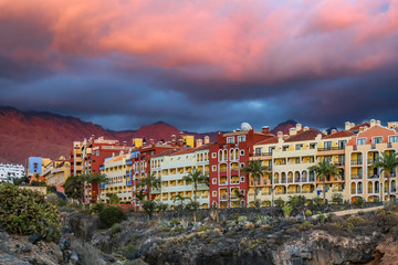 View to the ocean and rocky shore with buildings.