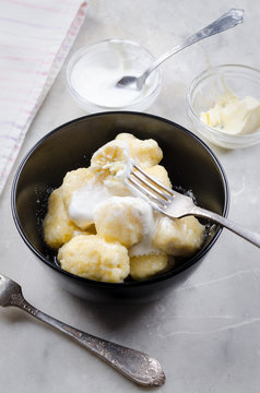 Lazy vareniki with cottage cheese (nioki) with sugar, butter and sour cream. Traditional European cuisine.