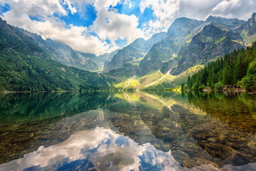 Beautiful alpine lake in the mountains, summer landscape with blue cloudy sky and reflection in crystal clear water, natural background, Morske Oko (Eye of the Sea), Tatra Mountains, Zakopane, Poland