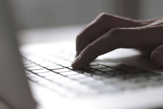 close up. blurred image of male hand typing on laptop keyboard