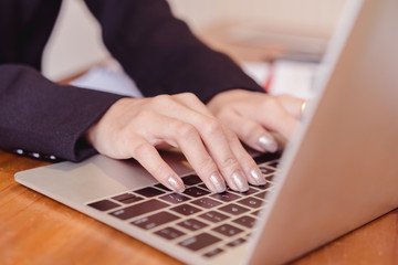 Close Up of business woman hands working on laptop computer.