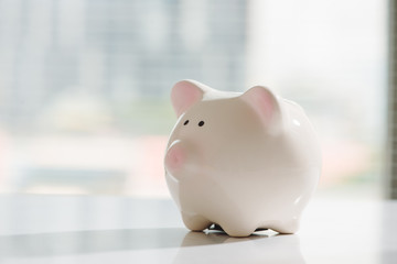 Lovely pink  piggy bank standing by the window