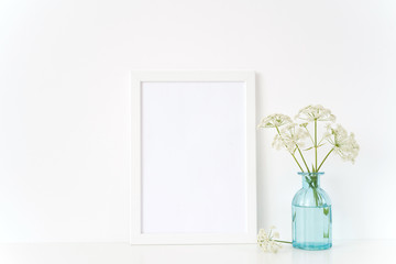 Summer white portrait a4 frame mock up with a wild host in transparent blue vase on white background . Mockup for quote, promotion, headline, design. Template for small businesses, lifestyle bloggers