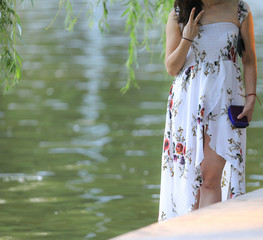 beautiful legs of a girl in a dress in an outdoor park