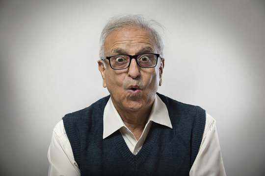 Senior man wearing spectacles making funny face