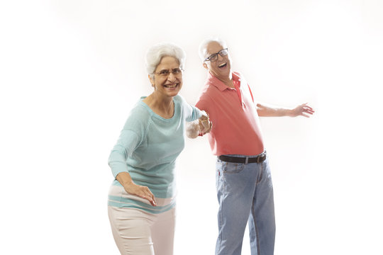 Smiling senior couple holding hands and dancing 