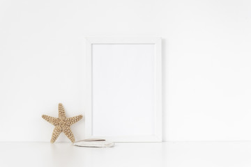 Minimal white frame mockup A4 in interior with sea elements . Frame mock up background for bloggers, social media, lettering, art and design. Indoor, frame on table. Summer sea mood