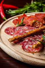 meat sliced proshto, salami, olives and pepper paprika on a wooden plate