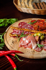 meat sliced proshto, salami, olives and pepper paprika on a wooden plate