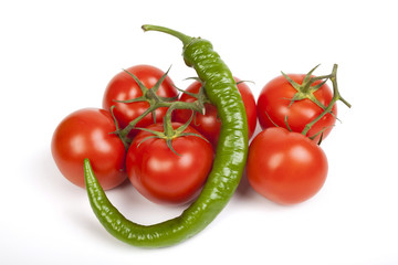 Tomatoes on the vine and Fefferoni, green Meditteranean semi-hot pepper on white background