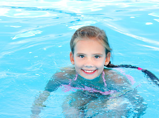 Fototapeta na wymiar Cute smiling happy little girl child in swimming pool