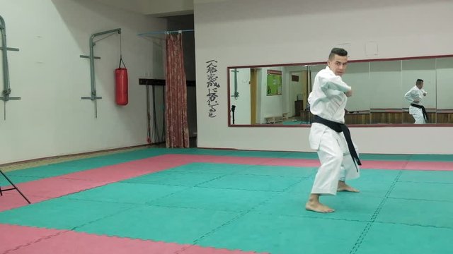 Young man with muscled body, training martial arts Goju-Ryu Karate-Do super slow motion
