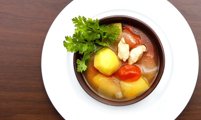Chicken potato soup with tomato in bowl