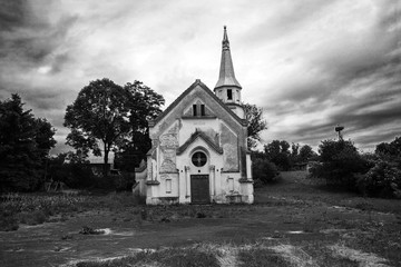Old abandoned church against dramatic dark sky, black and white photo