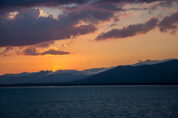 Naklejka premium Sunset through clouds with rays