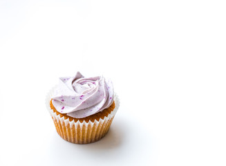 Home made muffin cupcake with blueberry icing, isolated on white background