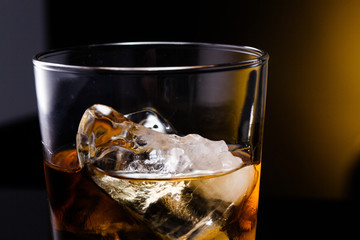 a glass with whiskey and ice on a background - 216825271