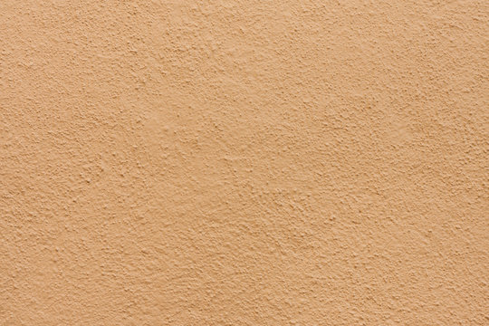 Stucco wall - Brown beige stucco textured wall background with natural light.
