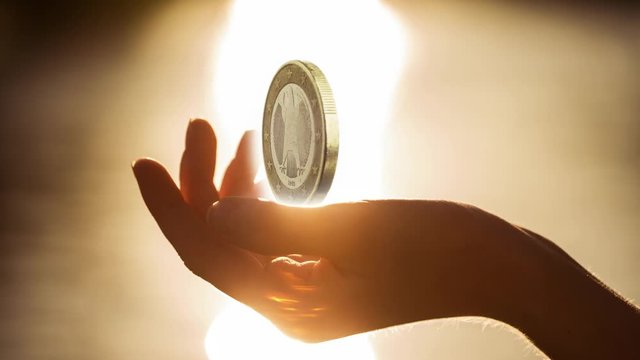 One Euro coin rotating in woman hands. looping movie. Cinemagraph