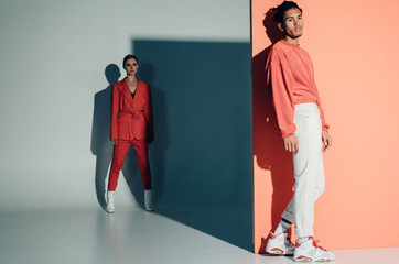 Casual couple in red leaning against a red wall
