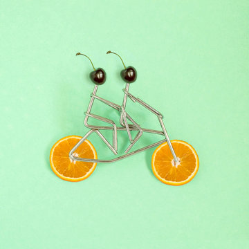 Metal figures of sportsmen on bicycle with wheels from orange