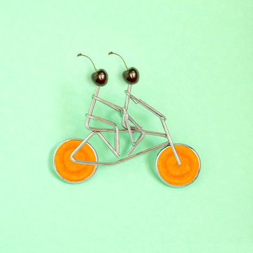 Metal figures of sportsmen on bicycle with wheels from carrot