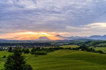 Obraz premium Mountains with last rays of setting sun during a colourful sunset.