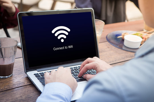 Businessman working and waiting for wi-fi connection using laptop / computer at the outdoor cafe