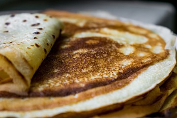 Appetizing golden pancakes with crispy crust, cooked at home. Fatty and hot pancakes on milk